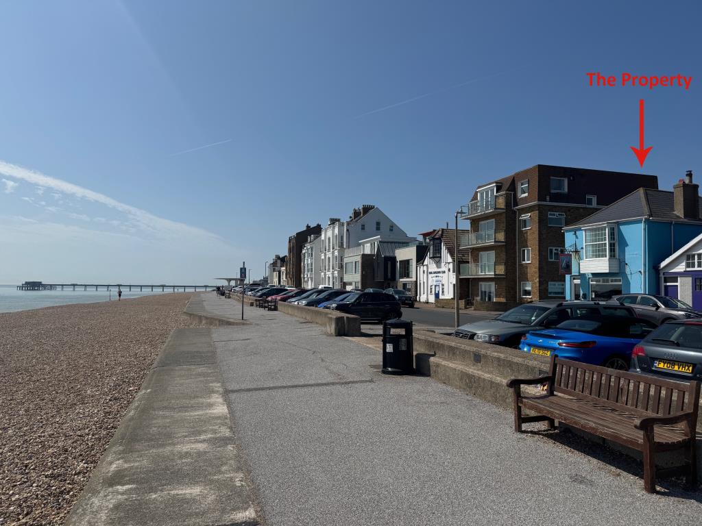 Lot: 122 - SEAFRONT PUBLIC HOUSE WITH THREE-BEDROOM FLAT WITH SEA VIEWS - General sea front view with building to the right